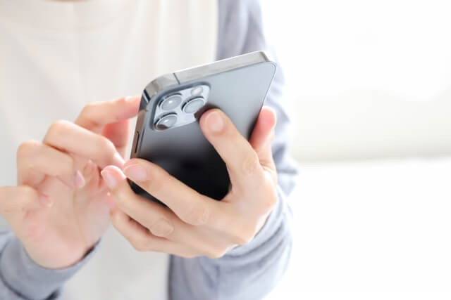 スマートフォンを操作する人の手元