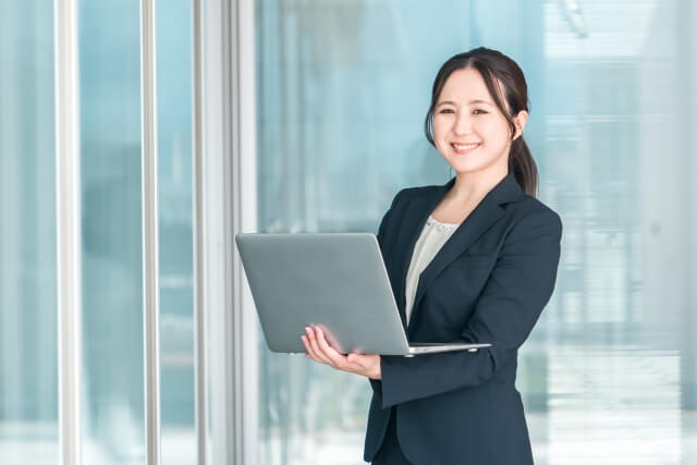 オフィスでノートパソコンを持つ女性